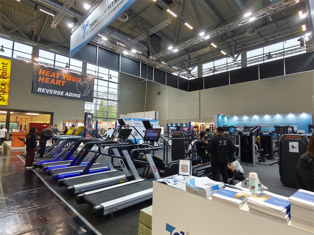 Visitors testing advanced cardio fitness equipment during the FIBO 2025 exhibition in Cologne.